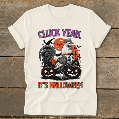 Rooster skeleton in Halloween scene with pumpkins and text "CLUCK YEAH, IT'S HALLOWEEN".