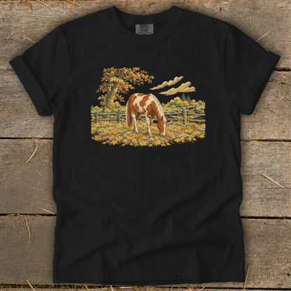 Black t-shirt with a painted horse grazing in an autumn landscape.