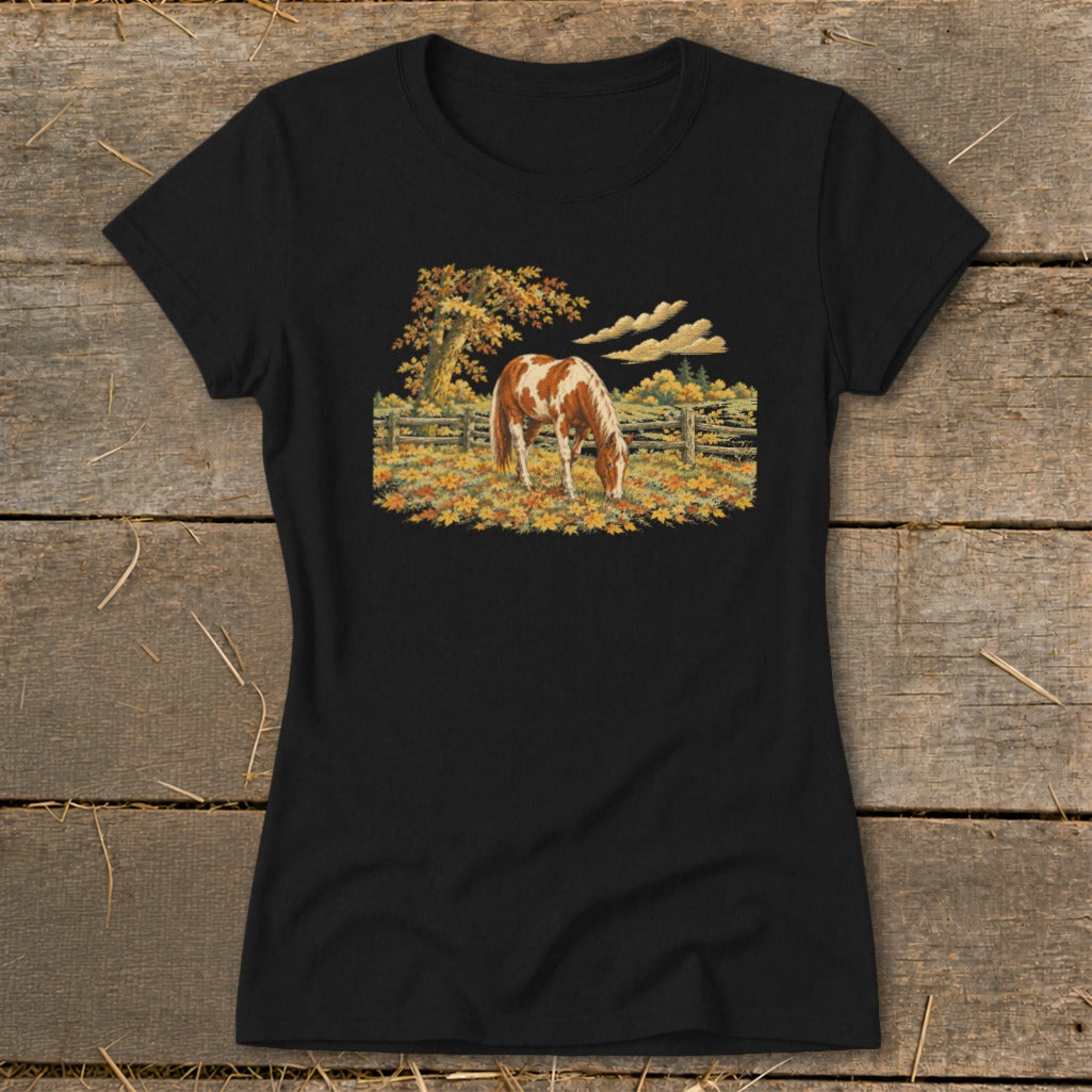 Black t-shirt featuring a pinto horse grazing in a field of autumn leaves.