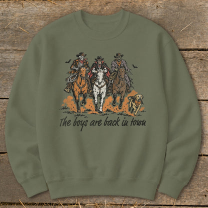 Three skeleton cowboys and a dog ride horses with text "The boys are back in town".