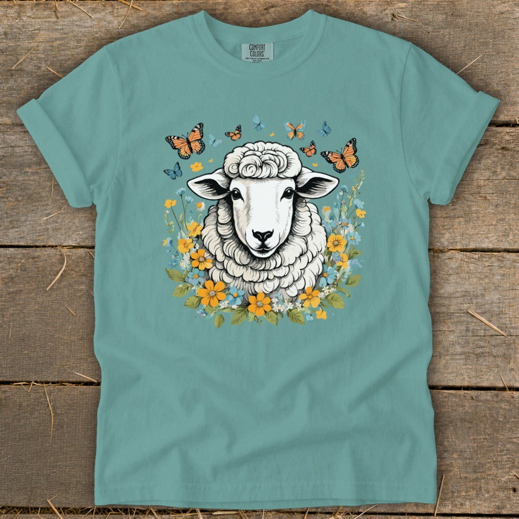 Sheep with butterflies and flowers design on a teal t-shirt.