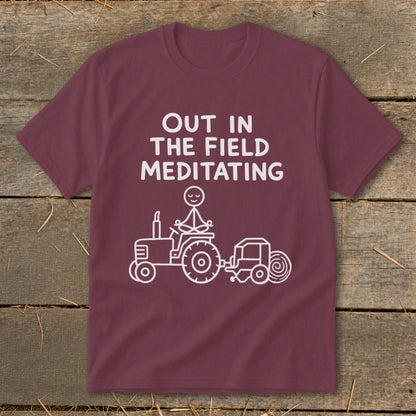 Maroon t-shirt with white text and graphic of stick figure meditating on tractor.