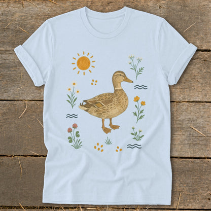 Light blue t-shirt with a watercolor-style mallard duck surrounded by flowers and sun.