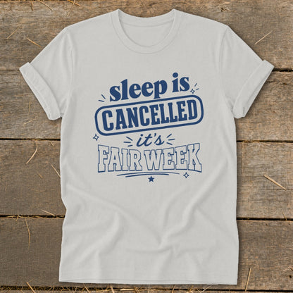 White t-shirt with blue text: "sleep is CANCELLED it's FAIR WEEK".