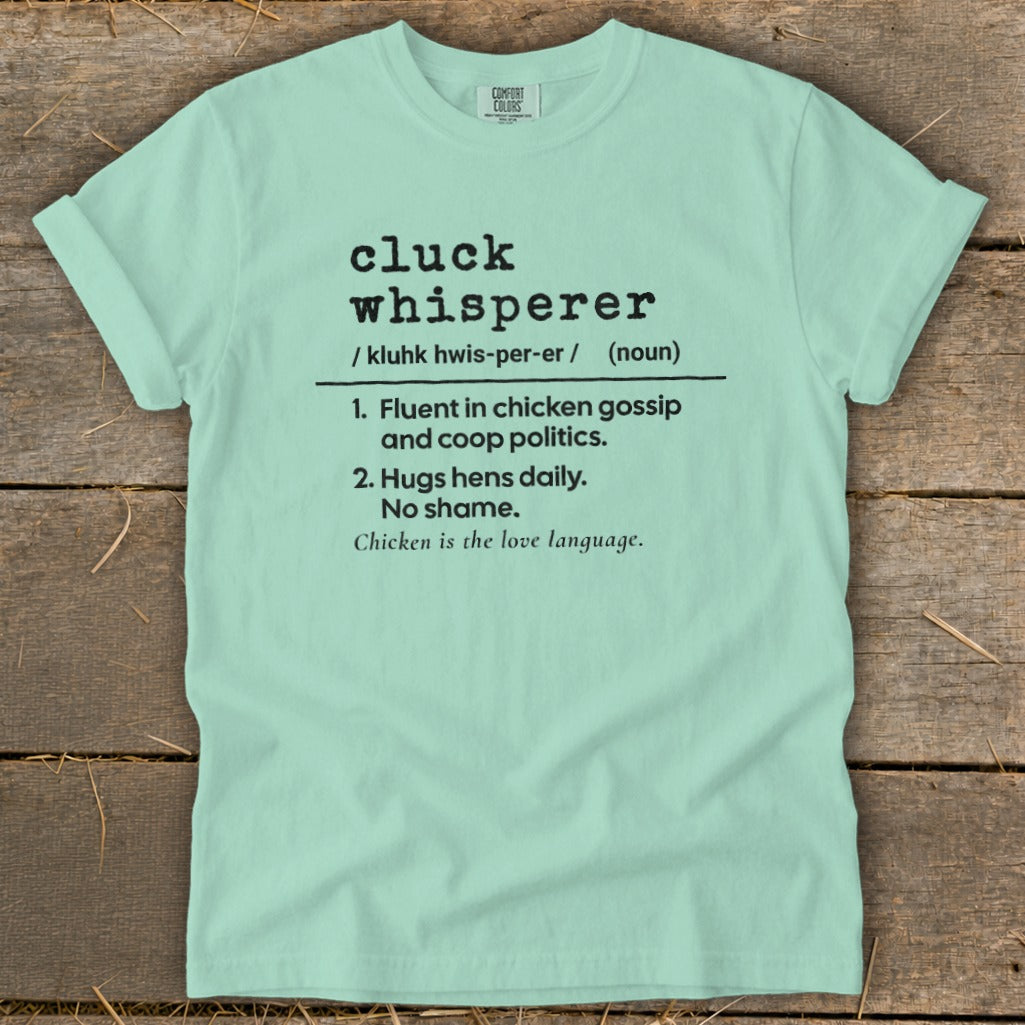Light mint t-shirt with "cluck whisperer" definition print and Comfort Colors tag.
