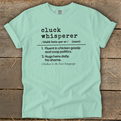 Light mint t-shirt with "cluck whisperer" definition print and Comfort Colors tag.