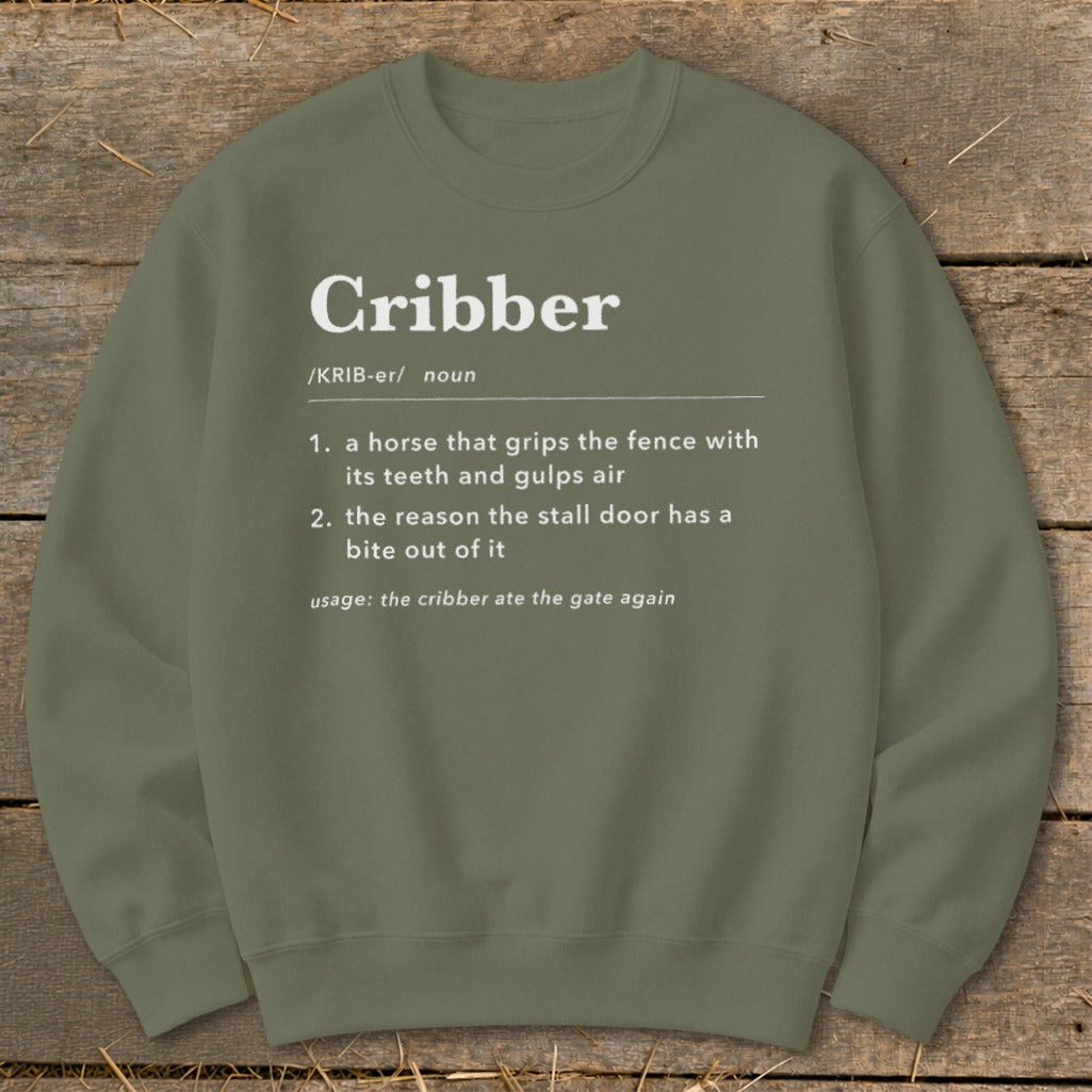 Olive green crewneck sweatshirt featuring a dictionary-style definition of the word cribber printed in white.