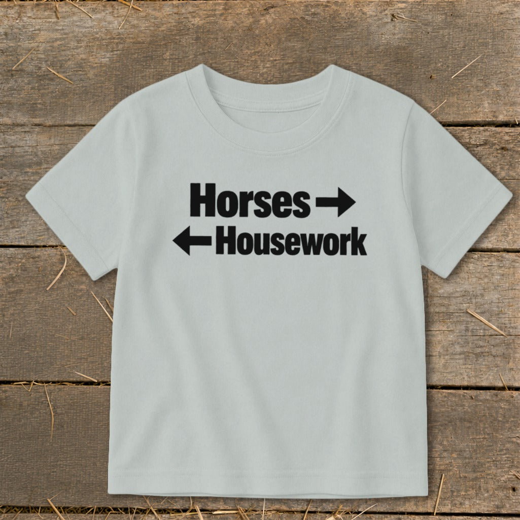 A light grey short-sleeved children's t-shirt printed with the text Horses and Housework and directional arrows.