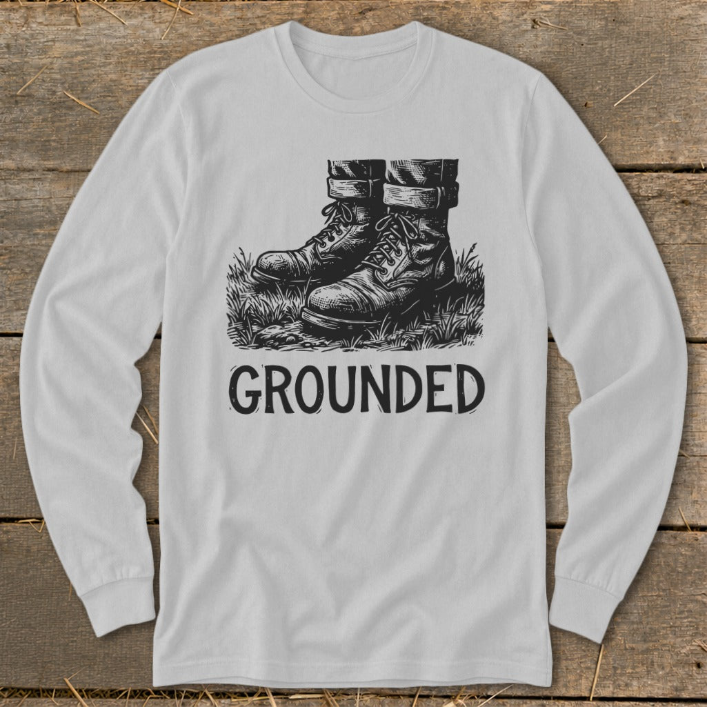 Long sleeve shirt with a drawing of boots on grass and the word "GROUNDED."