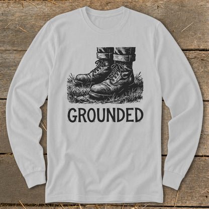 Long sleeve shirt with a drawing of boots on grass and the word "GROUNDED."