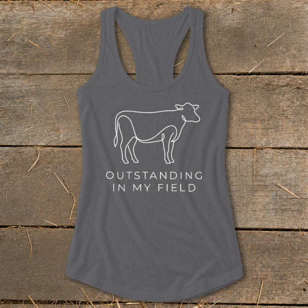 Gray racerback tank with a white line drawing of a cow and the text "OUTSTANDING IN MY FIELD".