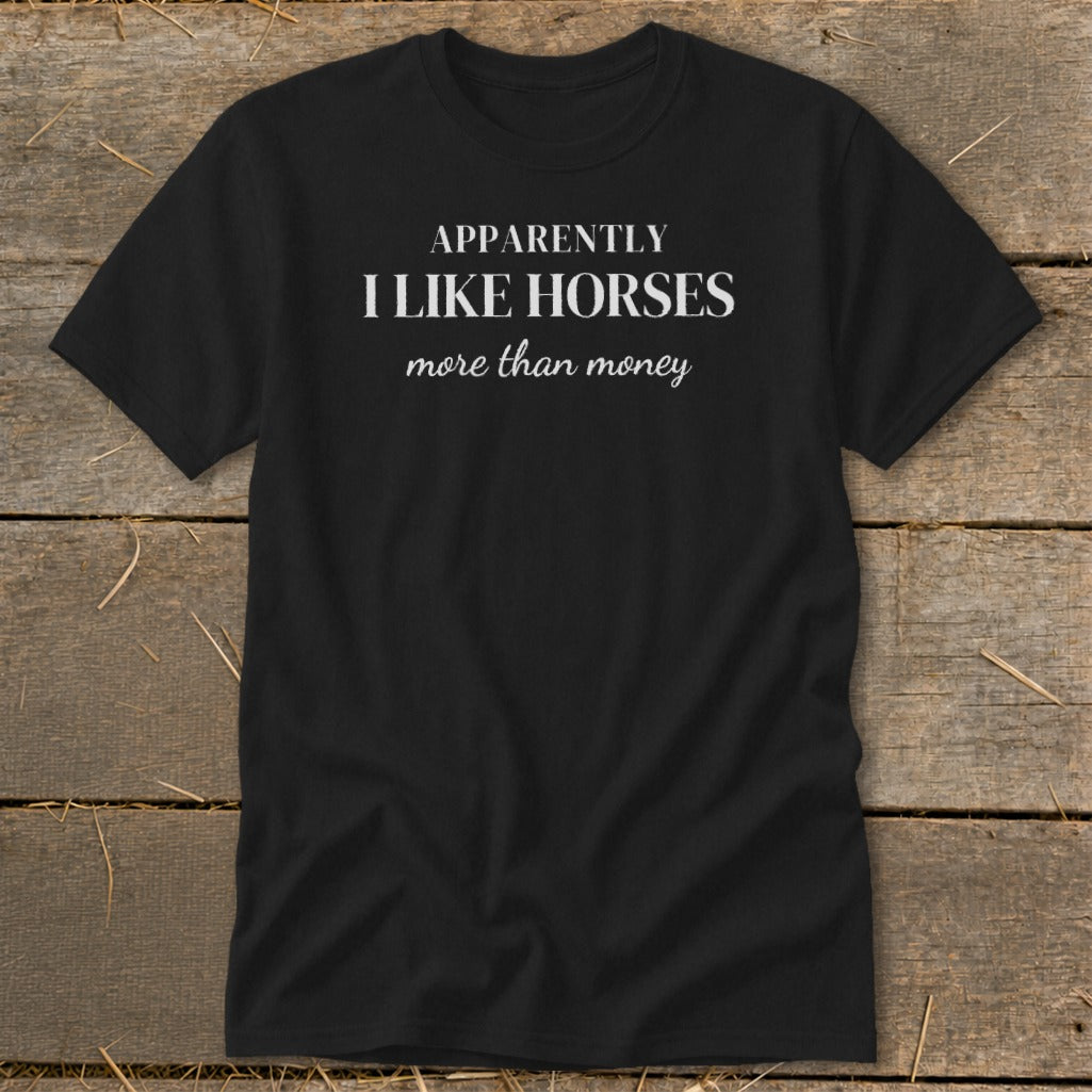 Black t-shirt with white text reading "APPARENTLY I LIKE HORSES more than money".
