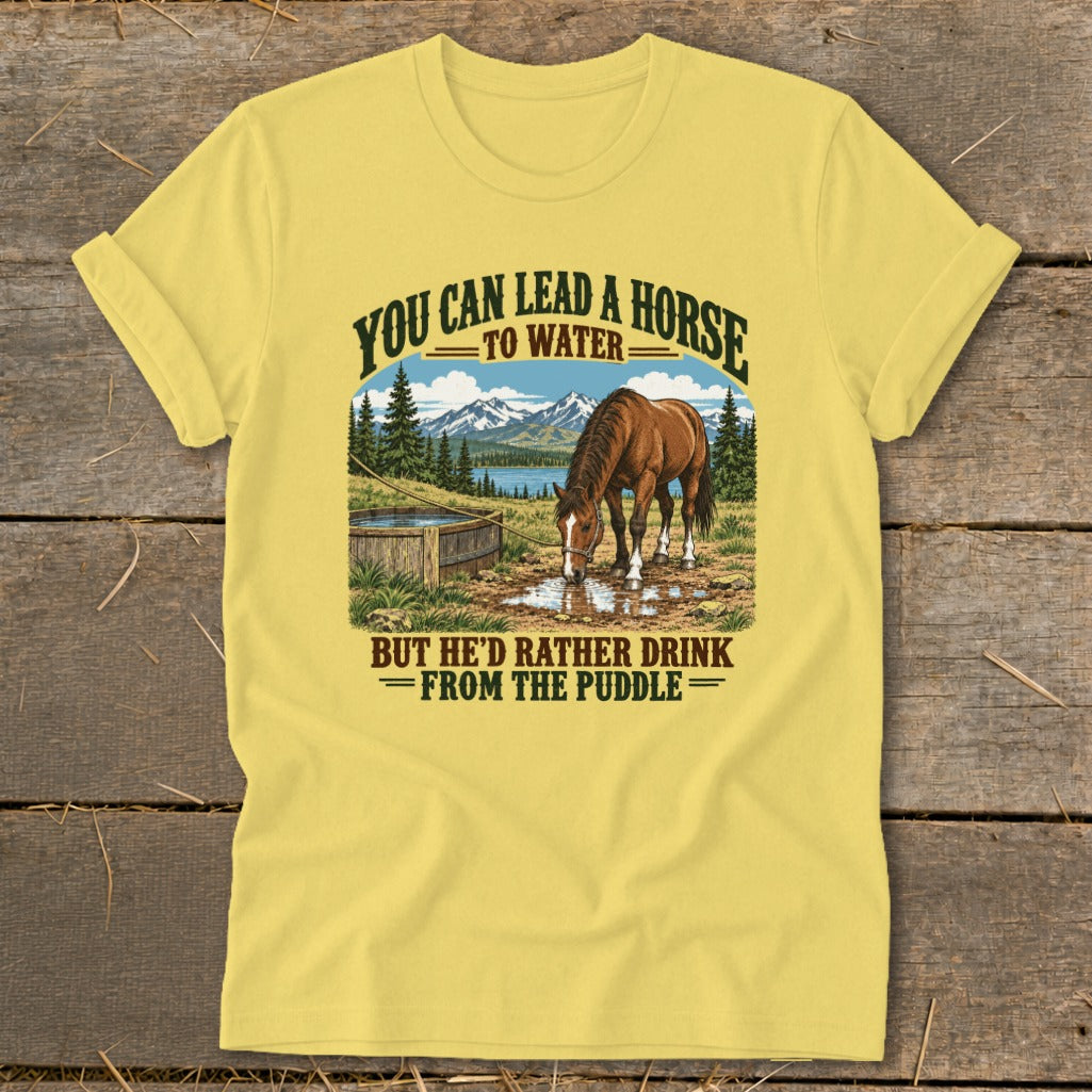 Yellow t-shirt featuring a graphic of a horse drinking from a puddle with text above and below.