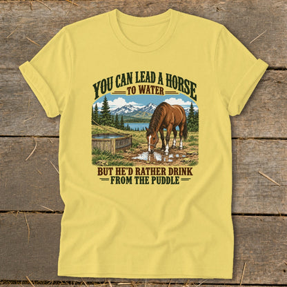 Yellow t-shirt featuring a graphic of a horse drinking from a puddle with text above and below.