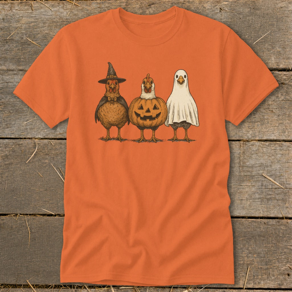 Three chickens in Halloween costumes: witch, jack-o'-lantern, and ghost.