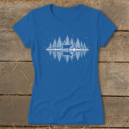 Blue t-shirt with white graphic of pine trees, a guitar, and a deer reflected in water.
