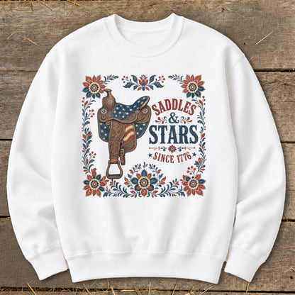 White sweatshirt with saddle, stars, and floral border reading "Saddles & Stars Since 1776".