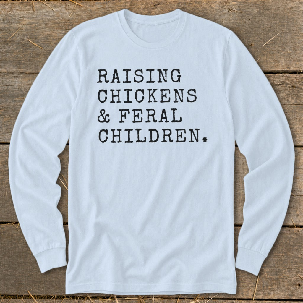 Light blue long sleeve shirt with black text: Raising chickens & feral children.