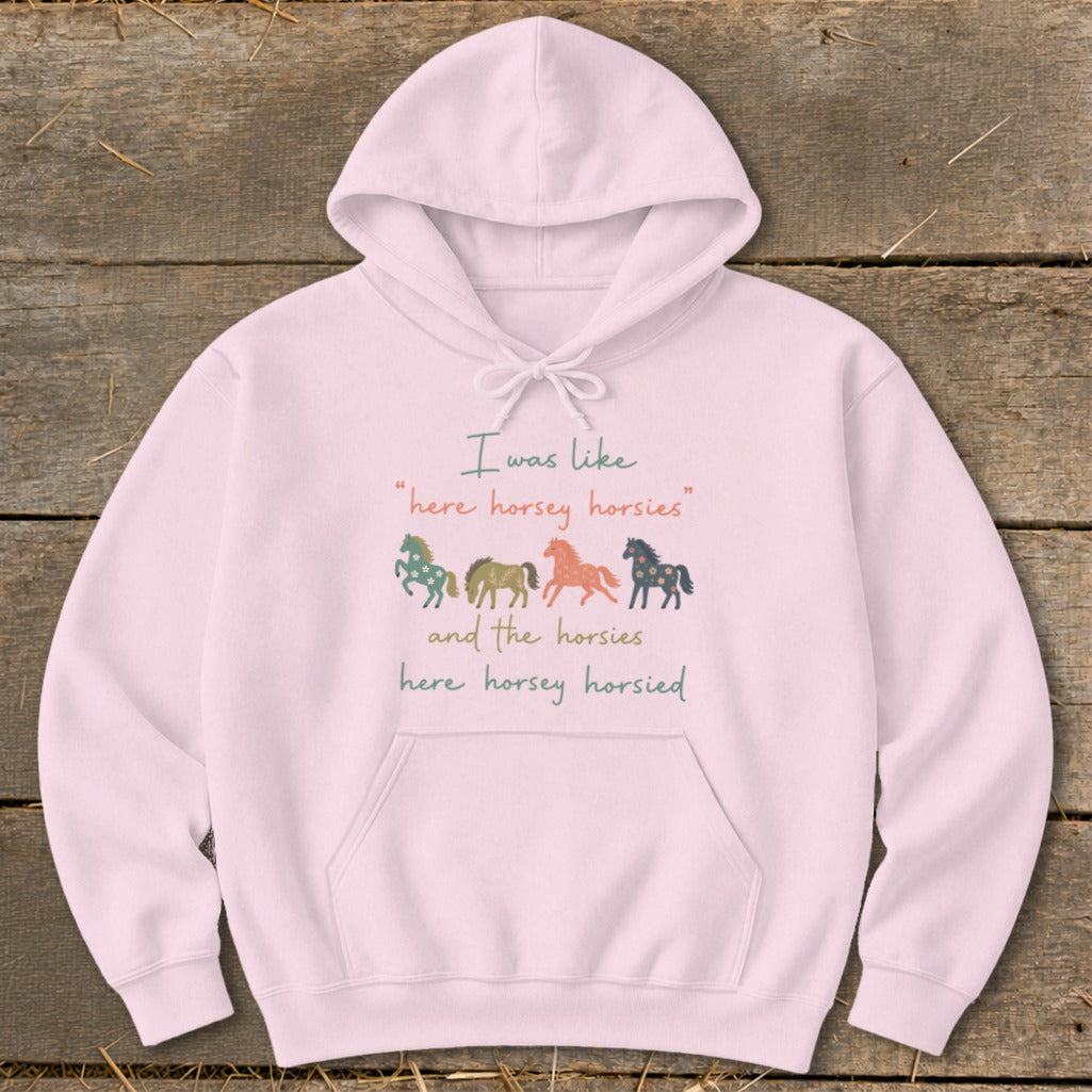 Pink hoodie with text and four colorful horse illustrations.