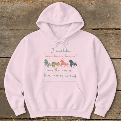 Pink hoodie with text and four colorful horse illustrations.