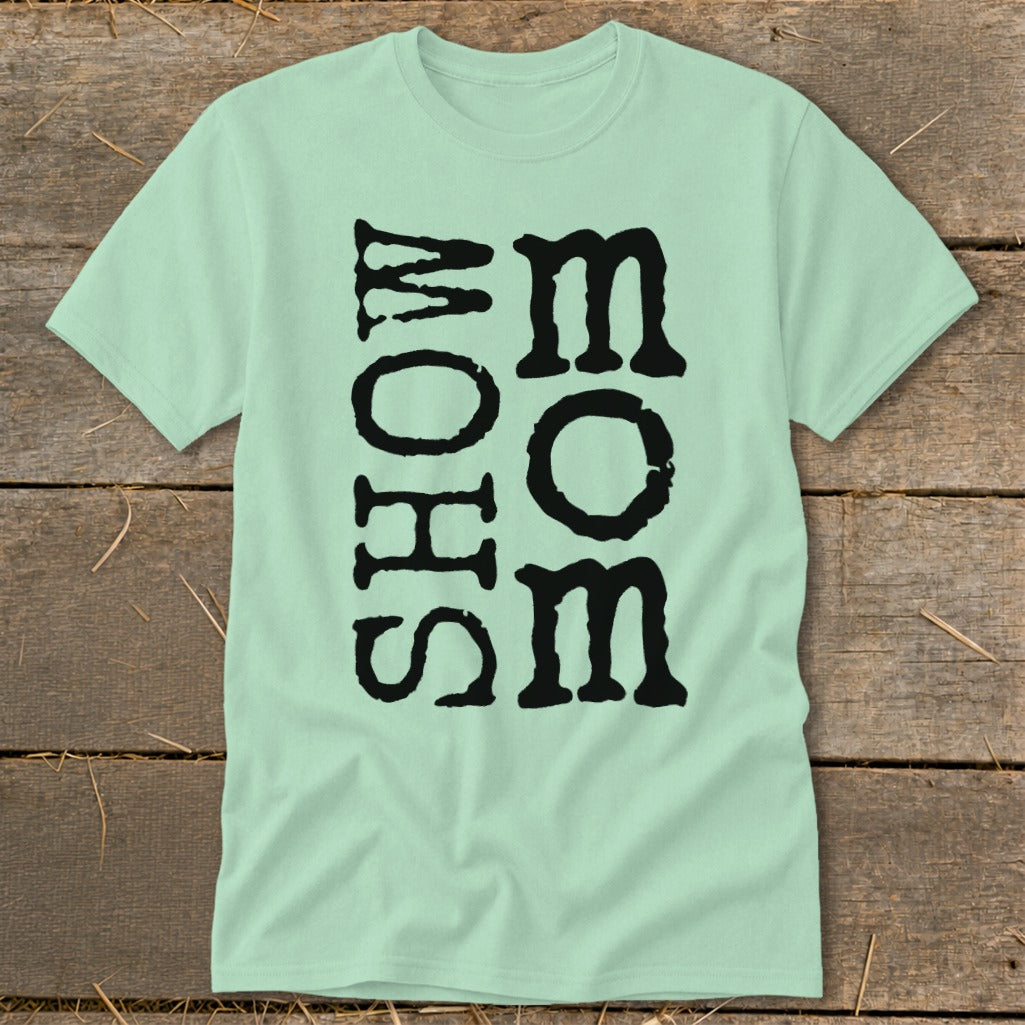 Light green t-shirt with black text reading "MOM" vertically next to "SHOW".
