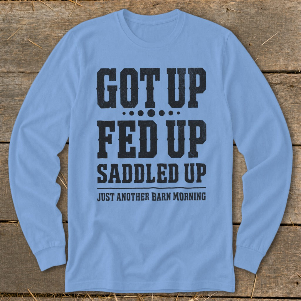 Light blue long-sleeve shirt with black text: "GOT UP FED UP SADDLED UP JUST ANOTHER BARN MORNING."