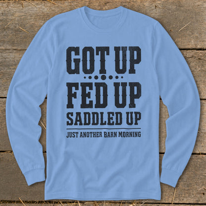 Light blue long-sleeve shirt with black text: "GOT UP FED UP SADDLED UP JUST ANOTHER BARN MORNING."