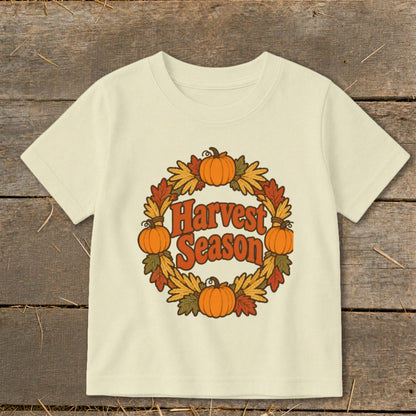 Cream t-shirt with "Harvest Season" text inside a pumpkin and leaf wreath.