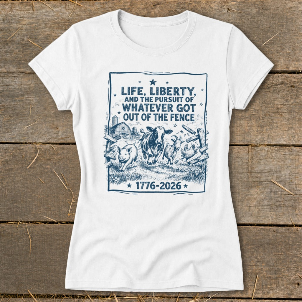 White t-shirt with a blue graphic of farm animals escaping a fence, "LIFE, LIBERTY, AND THE PURSUIT OF WHATEVER GOT OUT OF THE FENCE" and "1776-2026".