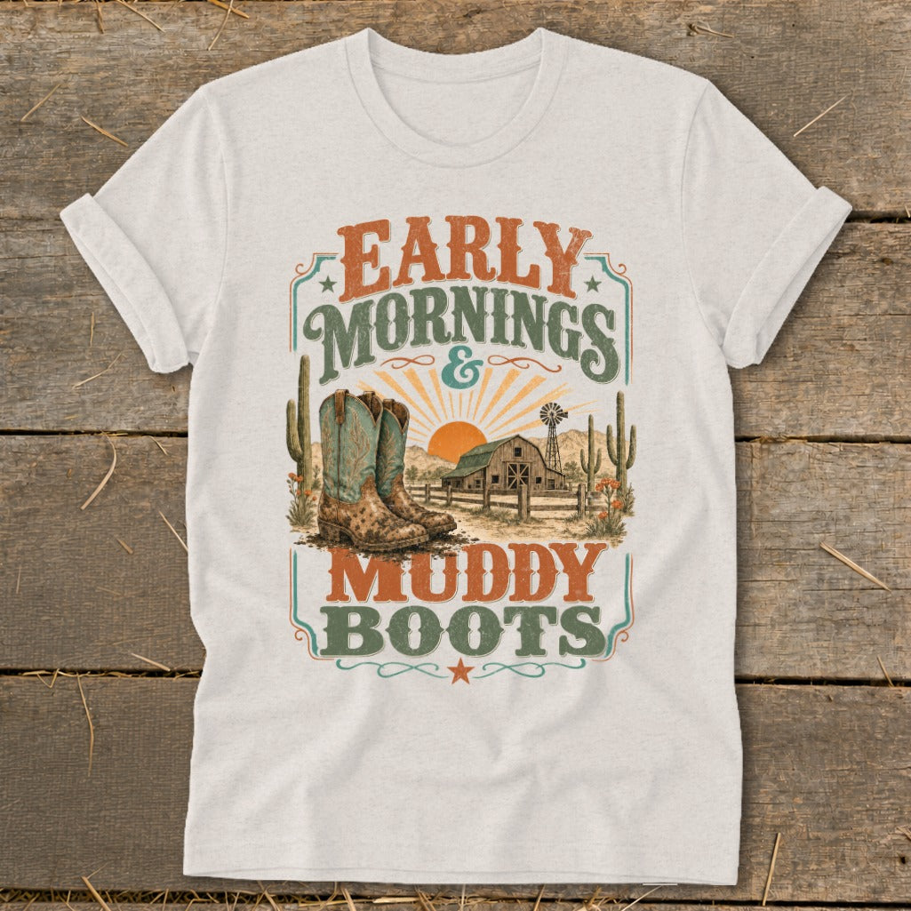 White t-shirt with "Early Mornings & Muddy Boots" graphic featuring cowboy boots, barn, and desert scene.