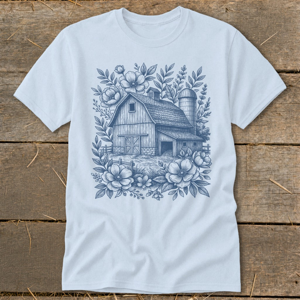 Light blue t-shirt with a blue sketch of a barn and flowers design.