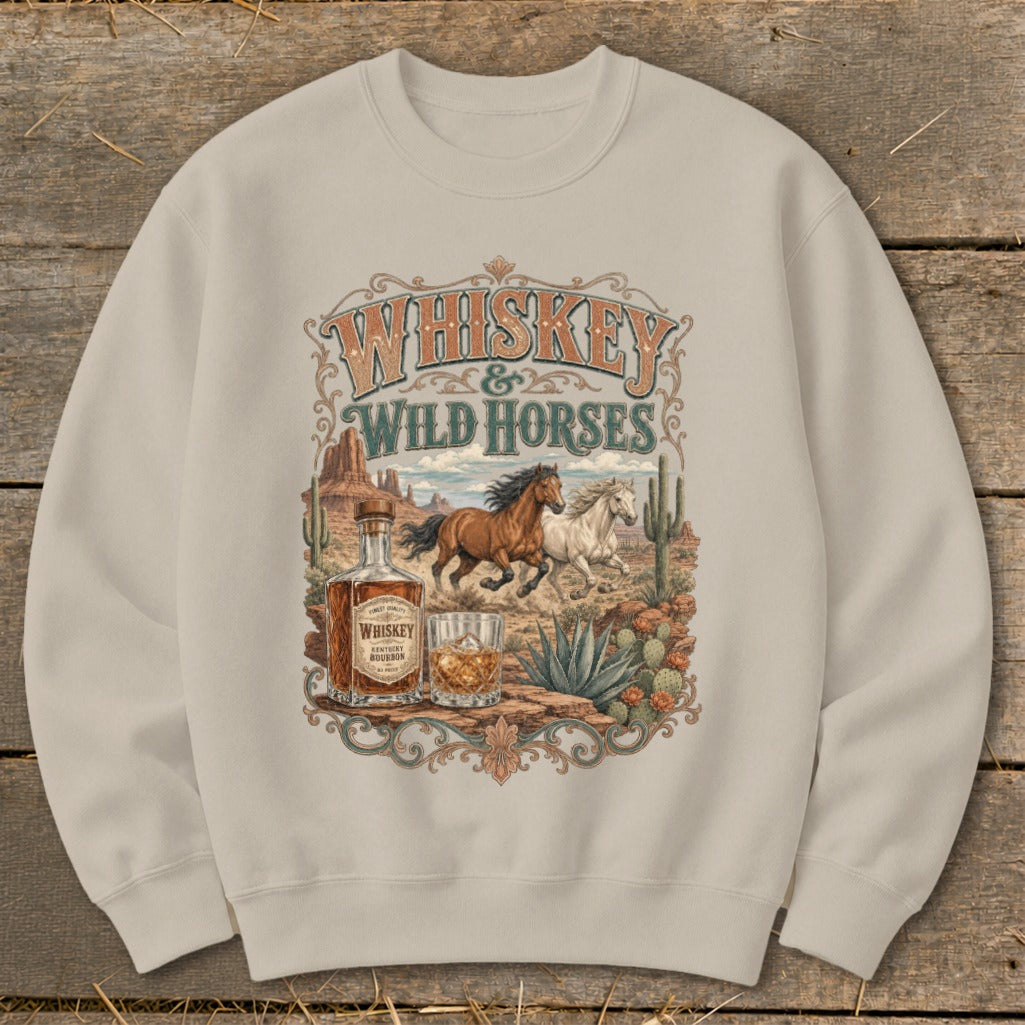 Sweatshirt with "Whiskey & Wild Horses" graphic featuring horses, whiskey bottle, and desert scene.