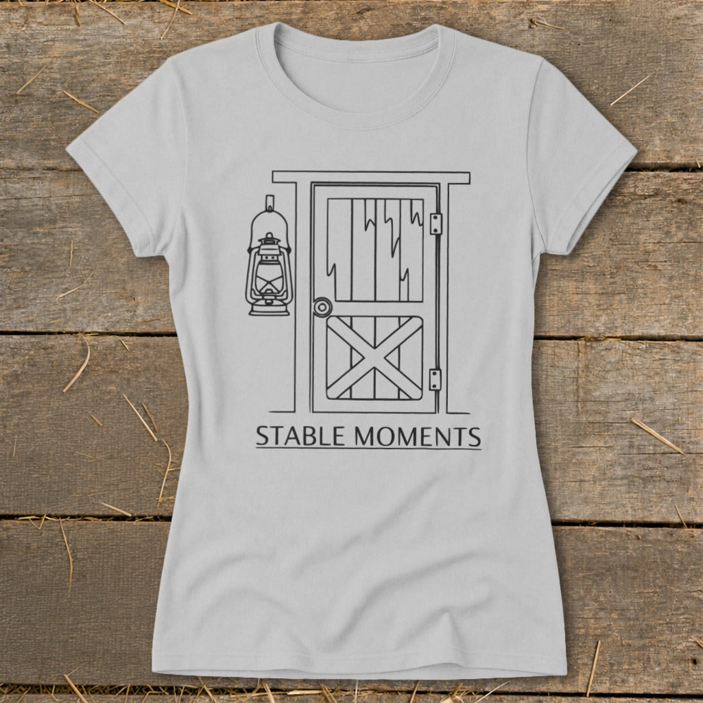Light grey t-shirt with a black line drawing of a barn door and lantern, text reads "STABLE MOMENTS".