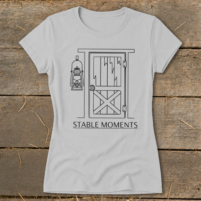 Light grey t-shirt with a black line drawing of a barn door and lantern, text reads "STABLE MOMENTS".