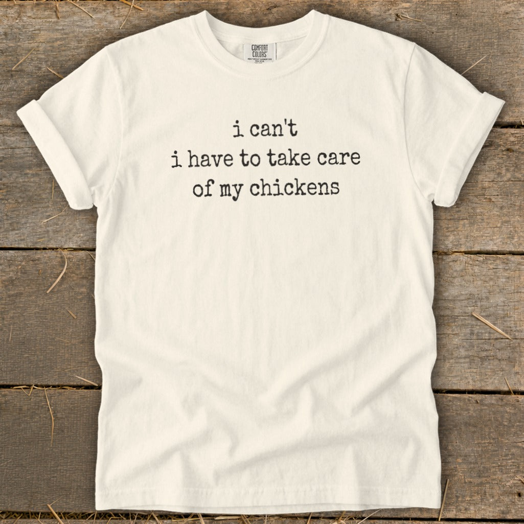 Cream t-shirt with black text that reads "i can't i have to take care of my chickens".