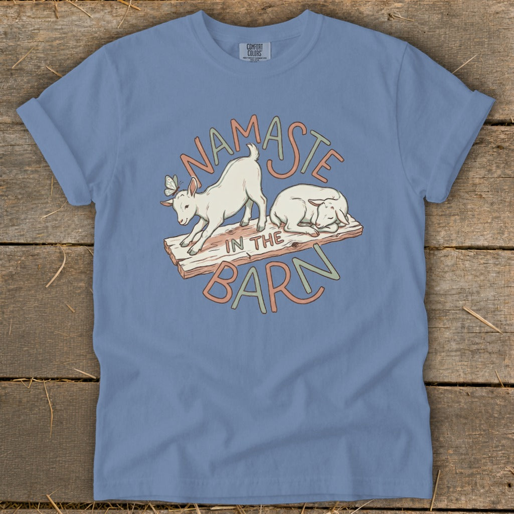 Blue t-shirt with graphic of two goats and the text "Namaste in the Barn".