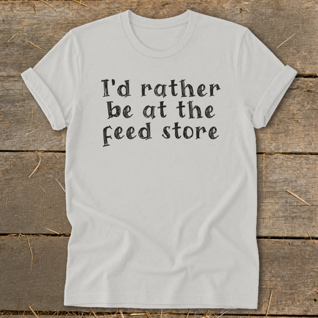 White t-shirt with black text reading "I'd rather be at the feed store."