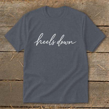 Grey t-shirt with white cursive text "heels down" centered on the chest.