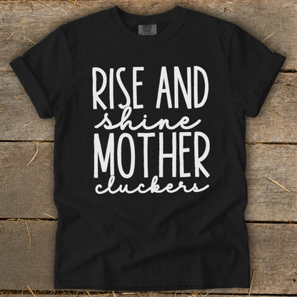 Black t-shirt with white text reading "Rise and shine mother cluckers".
