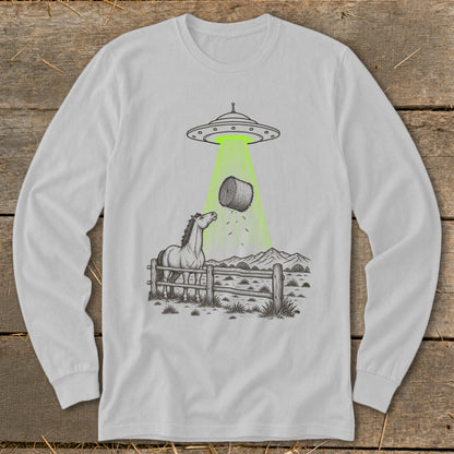 Horse looking up at hay bale being abducted by a UFO in a rural landscape.