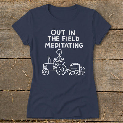 Dark navy t-shirt with white text and cartoon of person meditating on a tractor.