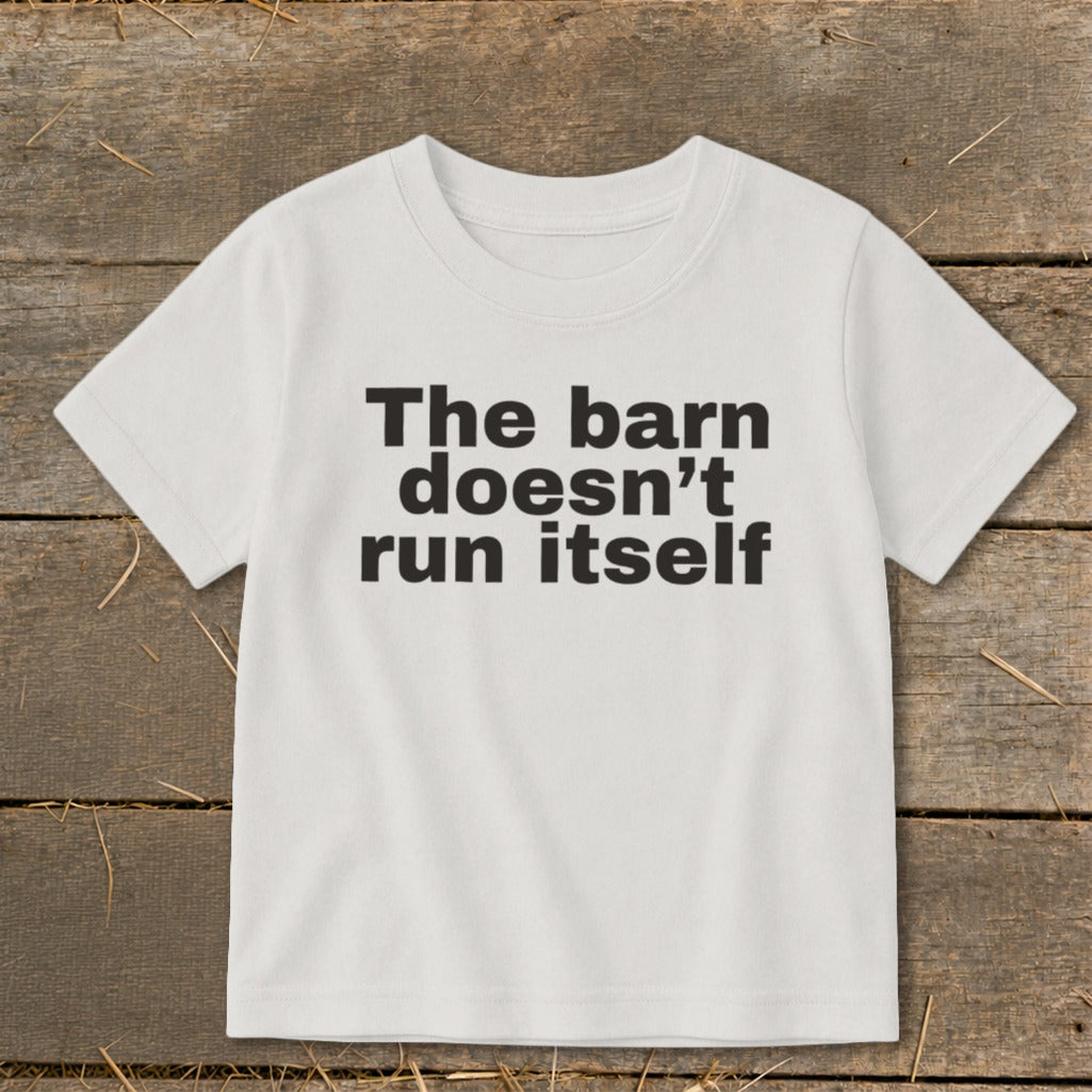 White t-shirt with black text reading "The barn doesn't run itself".