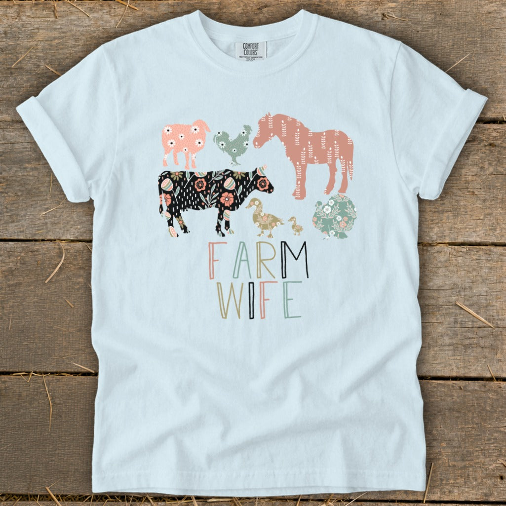 Light blue t-shirt with "Farm Wife" text and stylized farm animals in floral patterns.