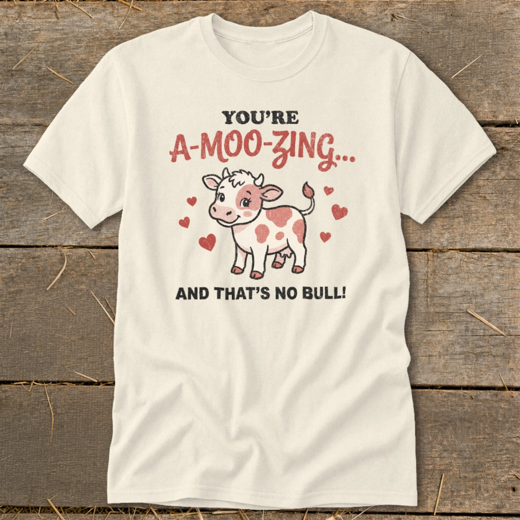 Cream t-shirt with a cartoon cow and the text "You're A-Moo-zing... And That's No Bull!".