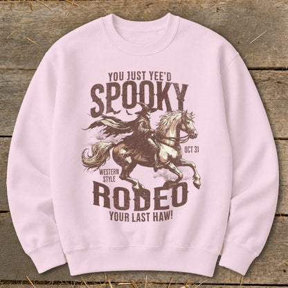 Light pink sweatshirt with spooky rodeo graphic and text.