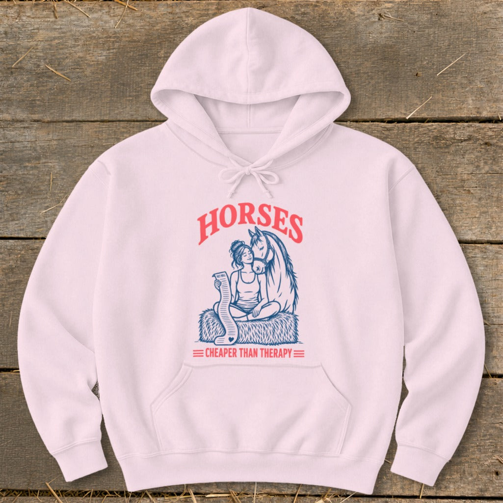 Pink hoodie with "HORSES CHEAPER THAN THERAPY" graphic of woman and horse.