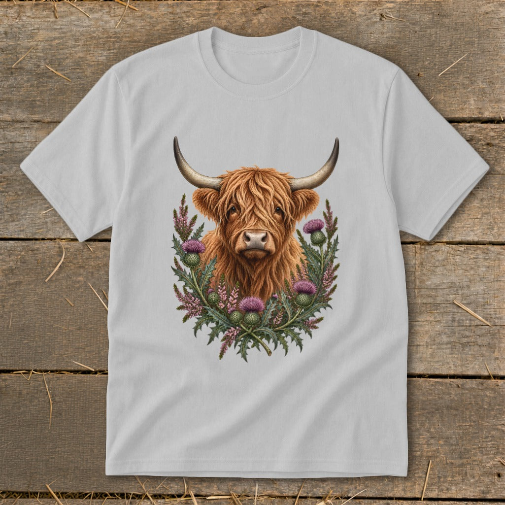 Highland cow with thistle wreath illustration on a light grey t-shirt.