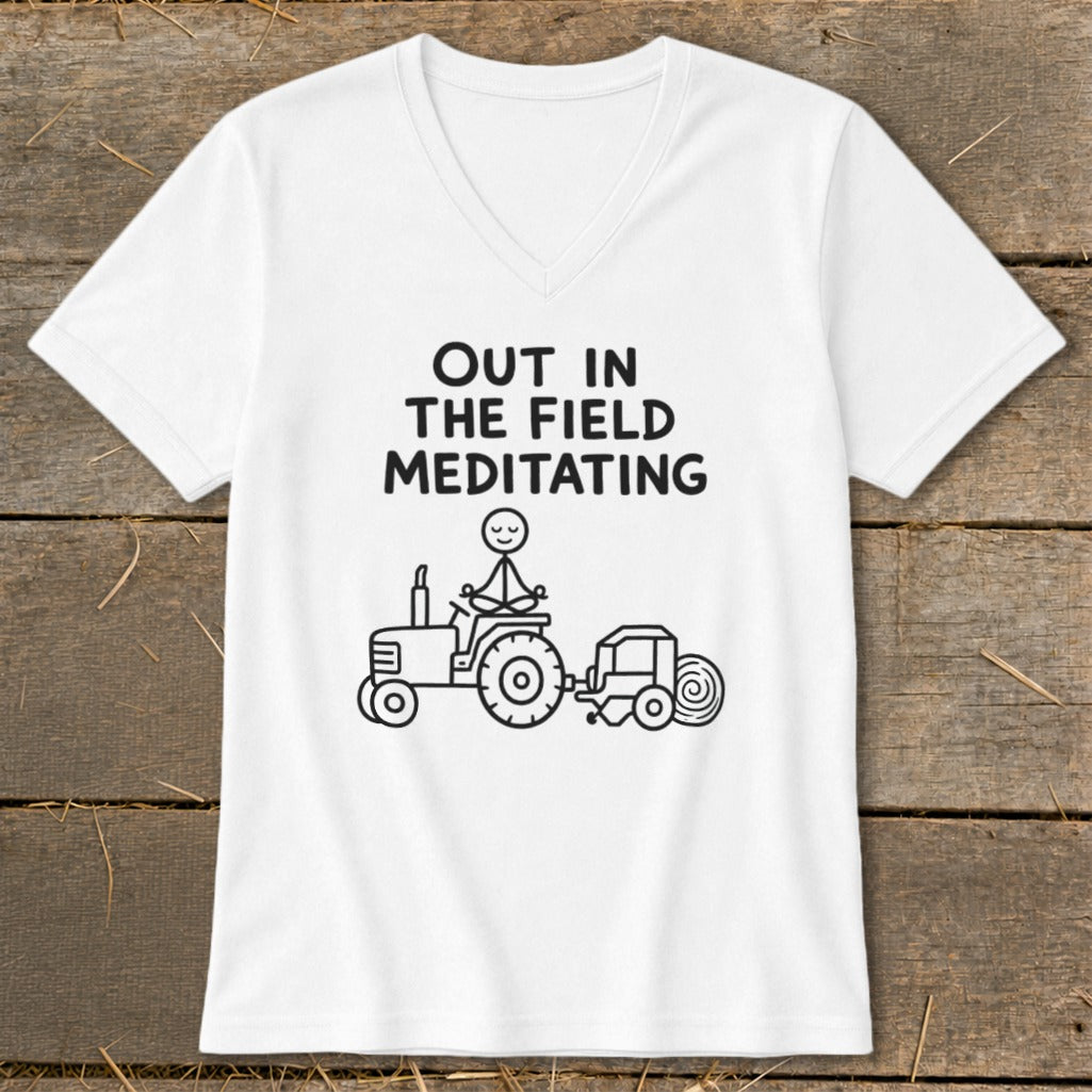 White t-shirt with text "OUT IN THE FIELD MEDITATING" and a stick figure meditating on a tractor.
