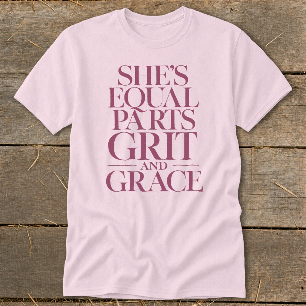 Light pink t-shirt with maroon text that reads "She's Equal Parts Grit and Grace".