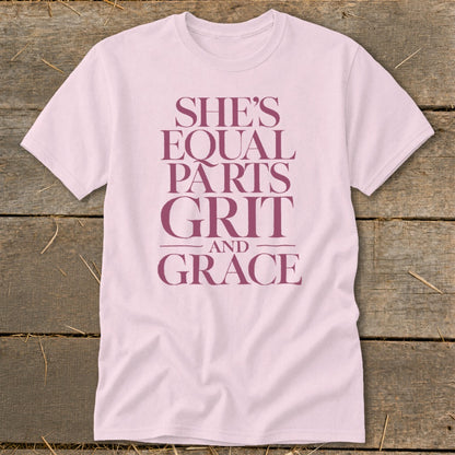 Light pink t-shirt with maroon text that reads "She's Equal Parts Grit and Grace".